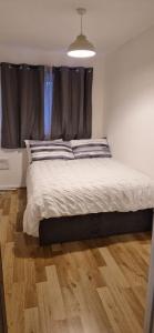 a bed in a bedroom with a wooden floor at Cozy one bedroom flat in Chatham +2 photos