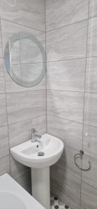 a bathroom with a white sink and a mirror at Cozy one bedroom flat in Chatham