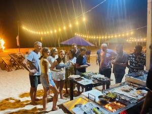 a group of people standing around a table with food at NN Beach Resort Nilaveli in Nilaveli +135 photos