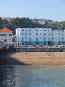 un grupo de personas en una playa cerca del agua en The White Rock Hotel, en Hastings