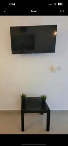 a black bench with two potted plants on a wall at Jolie condo in Boca Chica
