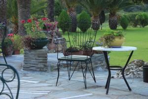 a patio with two chairs and a table with flowers at Garden House in Vourvourou