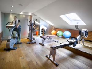 a gym with several exercise equipment in a room at K+K Hotel am Harras in Munich