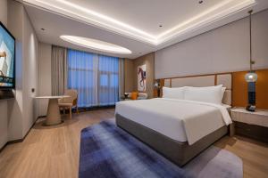 a hotel room with a large bed and a desk at Novotel Shanghai Hongqiao International Airport in Shanghai
