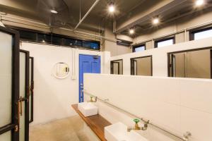 a bathroom with two sinks and a blue door at Bloo Hostel in Phuket Town