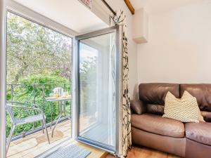 a living room with a couch and a sliding glass door at Inglenook Cottage in Ingleton