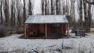 a small building with a tin roof in the snow at Cabaña La 40 "Relax y descanso en zona de chacras" in Buta Ranquil