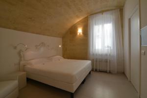 ein Schlafzimmer mit einem weißen Bett und einem Fenster in der Unterkunft Casa Blanca Matera in Matera