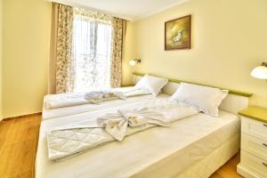 two beds in a bedroom with a window at Sirena Palace Family Hotel in Obzor