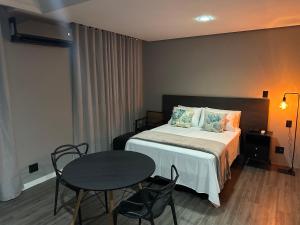 a bedroom with a bed and a table and chairs at Manaus Hotéis Millenium - Flat 804 in Manaus +15 photos
