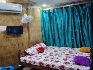 a bedroom with a bed and a blue curtain at MAMATA CROWN Inn in Bhubaneshwar