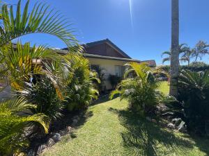 a house with palm trees in front of it at Lakeview Yamba River Side Waters in Yamba