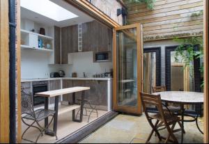 a kitchen and dining area with a table and chairs at Retreat to a Stylish 1 Bedroom Flat in Chelsea in London