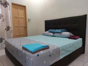 a bed with blue sheets and pillows on it at AIN's HOMESTAY in Kampong Mangka