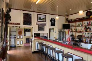 a restaurant with a bar and stools in a room at The Hideaway Hotel in Tiaro