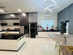 a large kitchen with white cabinets and a black refrigerator at 3KM to UTAR Sungai Long Party House 45Pax 20Car in Kajang