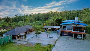 an aerial view of a house with a yard at Rainy Cloud Homestay - 1km Falls, Coffee Estate, Campfire, Home Food in Chikmagalūr
