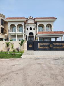 a large white house with a fence in front of it at CDA Park Enclave a tastefully furnished property ! in Islamabad