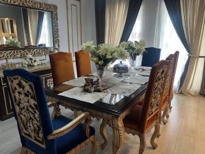 a dining room with a table and chairs with flowers on it at CDA Park Enclave a tastefully furnished property ! in Islamabad