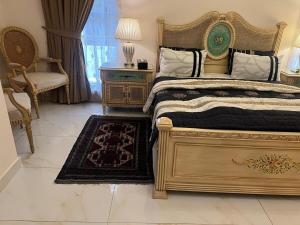 a bedroom with a bed and a chair and a table at CDA Park Enclave a tastefully furnished property ! in Islamabad
