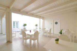 uma sala de jantar branca com uma mesa e cadeiras em Casa Blanca Matera em Matera
