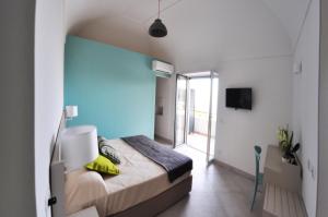 a bedroom with a bed with a blue wall at Casa Costanza in Capri