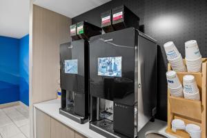 a coffee shop with a large black refrigerator at Holiday Inn Express - Sunnyvale - Silicon Valley by IHG in Sunnyvale