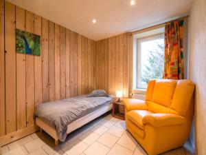a bedroom with a bed and a chair and a window at Tranquil Escape, Sourbrodt in Waimes +31 photos