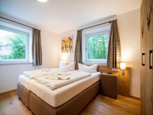 a bedroom with a large bed with two windows at Chalet in Zell am See near Ski Slopes in Bruck an der Großglocknerstraße
