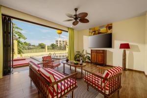 a living room with chairs and a table and a large window at Antique Hoi An By S'cape Staycation in Tân Thành (1)