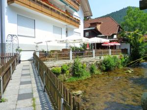 un edificio con una valla junto a un río en Landgasthof-Hotel-Rössle, en Oberprechtal