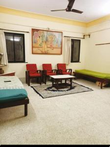 ein Wohnzimmer mit Sofa, Tisch und Stühlen in der Unterkunft Esha's Homely stay in Indāpur