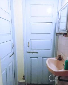 ein Badezimmer mit einer weißen Tür und einem Waschbecken in der Unterkunft Esha's Homely stay in Indāpur