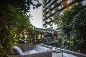 a patio with chairs and a table and a building at The Nicolaus Hotel in Bari