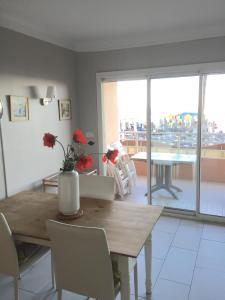 uma sala de jantar com uma mesa e vista para uma varanda em Appartement Front de Mer em Canet-en-Roussillon