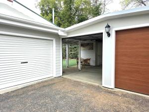 a garage with two garage doors and a table at Armidale Cottage on Taylor unit 4 in Armidale