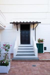 - un bâtiment blanc avec une porte et des escaliers noirs dans l'établissement Relais del Corso, à Sorrente