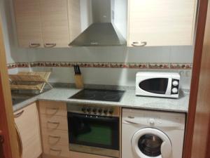 a kitchen with a microwave and a washing machine at RealRent La Antilla in Moncófar