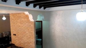 una camera con un muro di mattoni e due lampadari a ciondolo di Reem a Temara