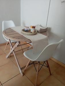 un tavolo con una sedia bianca e un tavolo con una ciotola di Yakhe self-catering Cozy styled 1 bedroomed a Edenvale