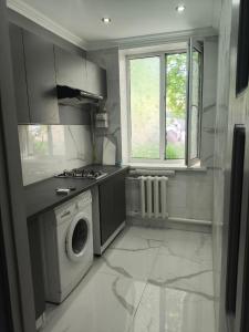 a kitchen with a stove and a washing machine at Miledi in Bălţi