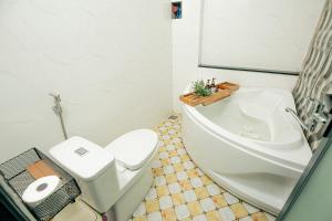 a bathroom with a tub and a toilet and a sink at Rustic Homestay Bình Dương in Phú Lợi