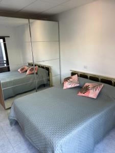 a bedroom with two beds with pink pillows at Apartamento Las Canteras in Las Palmas de Gran Canaria