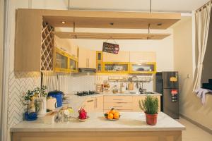 a kitchen with yellow cabinets and oranges on a counter at Iris Homestay Bình Dương in Trạm Chánh An