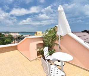 a balcony with an umbrella and a table and chairs at Sirena Palace Family Hotel in Obzor