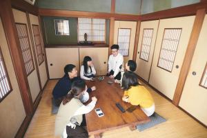 a group of people sitting around a wooden table at Song Yin Pavilion / Vacation STAY 78854 in Shimosato