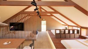 南小国町库拉萨科温泉樱花度假屋的一间带木制天花板的客厅和一间带电视的客房。