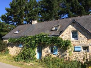 una casa de piedra con techo negro en Histoire de, en Guidel