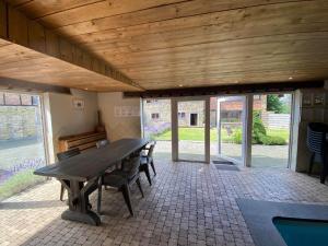 a large patio with a wooden table and benches at Spacious Waimes Villa in Waimes