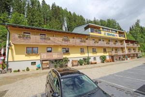 um carro estacionado em frente a um grande edifício em Gasthof Käferhube em Murau